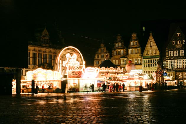 Der Kleine Freimarkt in Bremen in der Ferne erleuchtet den Rolandsplatz am späten Abend.