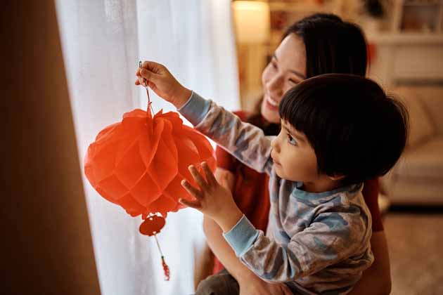 Eine Mutter und ihr Kind schmücken für das chinesische Neujahrsfest.