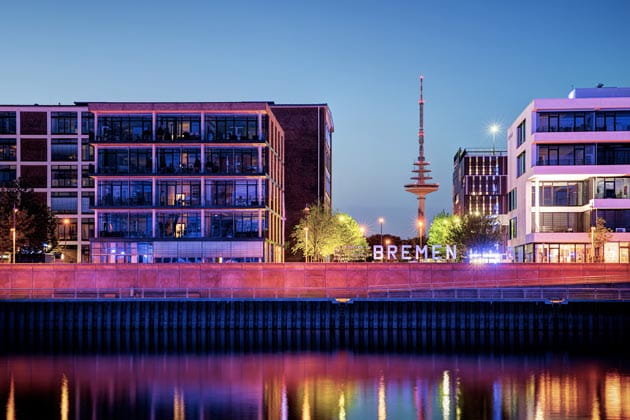 Der Europahafen in der Bremer Überseestadt wird mit bunten Lichtern beleuchtet.