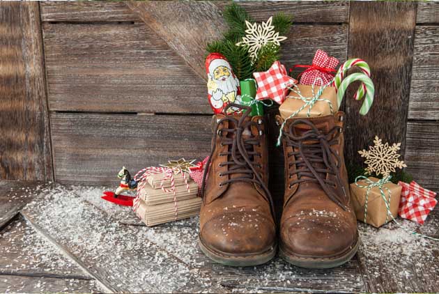 Ein paar braune Schuhe sind zum Nikolaus mit Geschenken und Schokolade gefüllt.