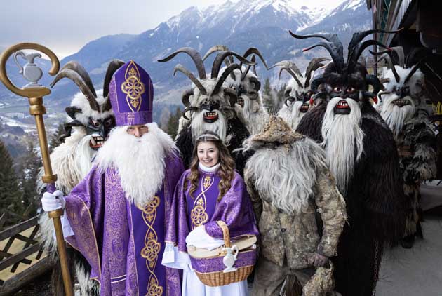 Der Nikolaus in lila mit vielen als dämonischer Krampus verkleideten Begleitern in der Alprenregion.
