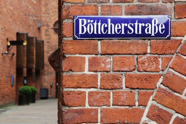 Ecke einer roten Ziegelsteinmauer mit dem Schild "Böttcherstraße" darauf.
