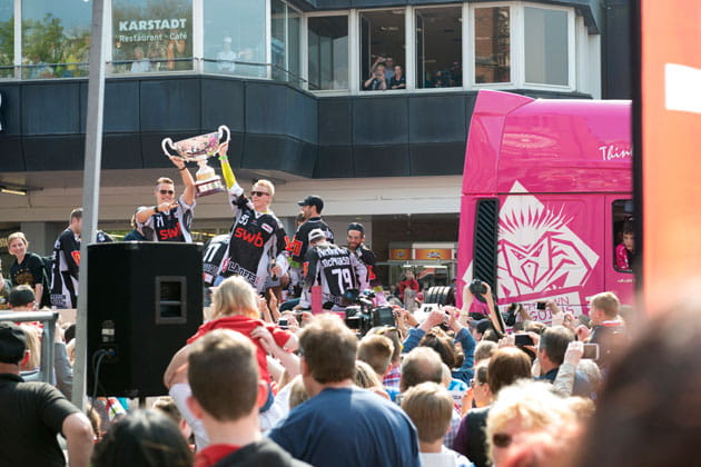 Die Fishtown Pinguins feiern in der Menschenmenge und halten den Pokal der 2. Deutschen Eishockey Liga in die Höhe.