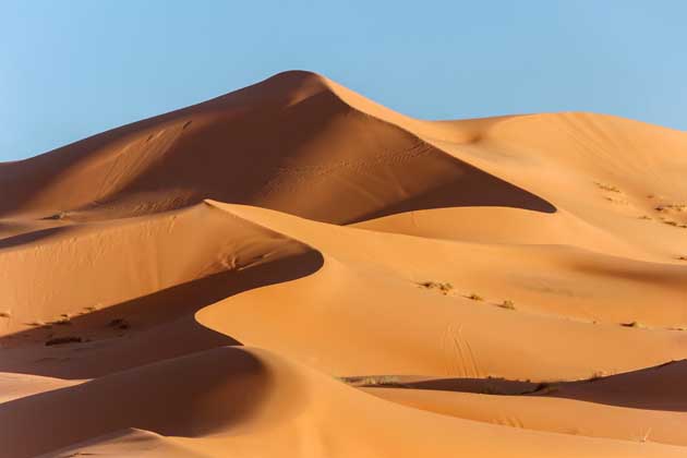 Eine große Sanddüne an einem sonnigen Tag in der Wüste.