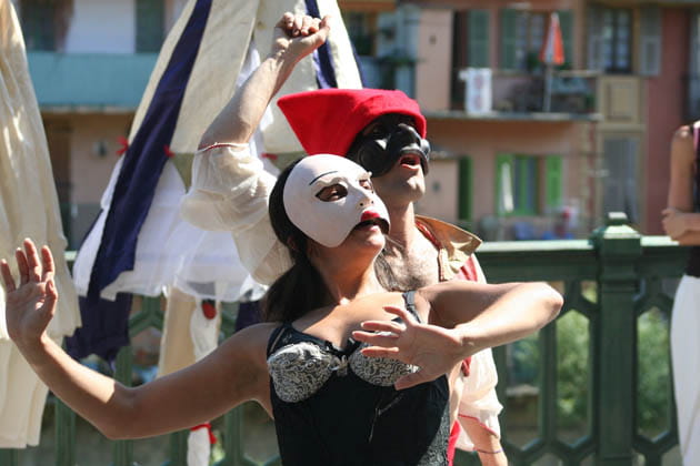 Ein Mann und eine Frau, die mit Masken verkleidet, Straßentheater mitten in der Stadt bieten