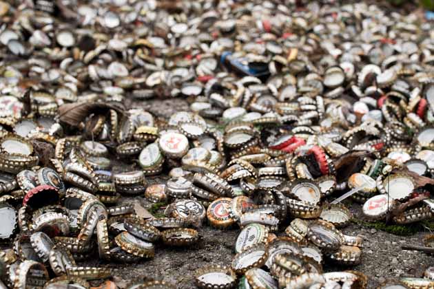 Hunderte, teilweise rostige Kronkorken liegen auf dem Boden.