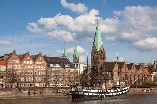 Die Schlachte in Bremen mit angelegtem Schiff sowie die St.-Martini-Kirche mit Turmspitzen des Bremer Doms im Hintergrund.