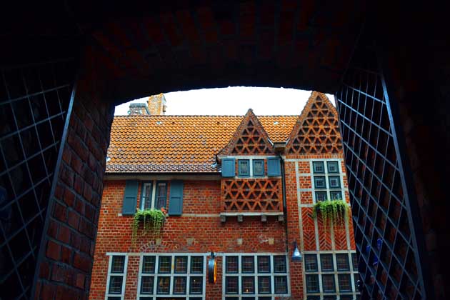 Blick durch ein altes Stadttor Bremens auf eine alte Hausfassade.