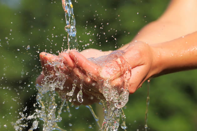 Hände, die plätscherndes, sauberes Wasser auffangen
