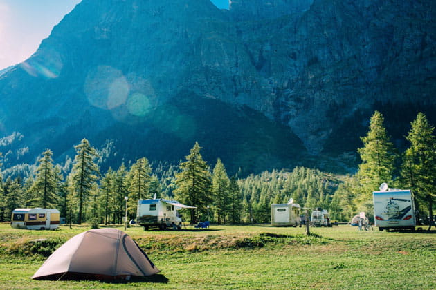 Campingplatz mit Zelten und Wohnwägen in den grünen Bergen Italiens