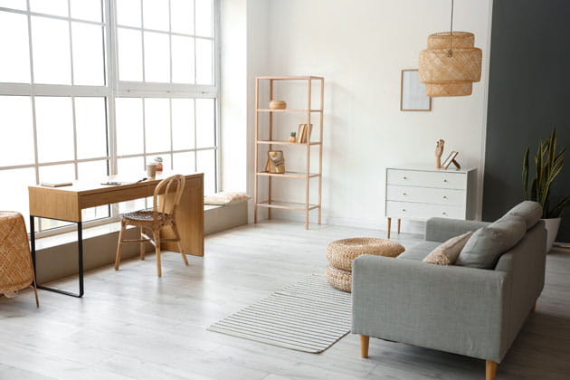 Minimalistisches Interieur eines hellen Wohnzimmers in Holzoptik mit Schreibtisch, Sessel, Teppich und Regal 