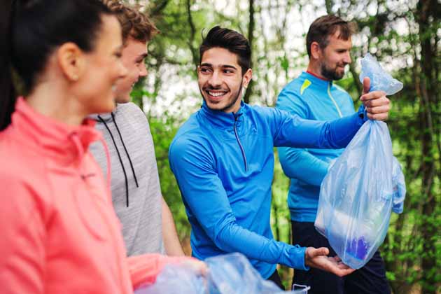 Eine Gruppe von jungen Menschen in Sportkleidung haben geploggt, also Müll aus dem Wald gesammelt.
