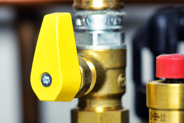 Ein Heizungsrohr mit einem gelben drehbaren Ventil