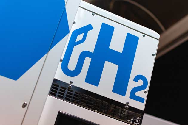 Eine weiße Wasserstofftankstelle, die mit einem blauen "H2" bemalt ist.