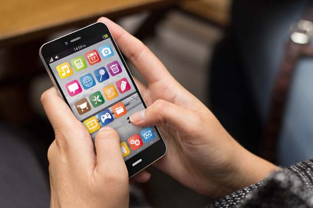 Zwei Finger bedienen ein Smartphone mit verschiedenen Apps auf dem Bildschirm.