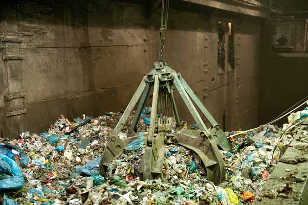 Ein Müllgreifer in einem Müllheizkraftwerk vermischt die Abfälle.