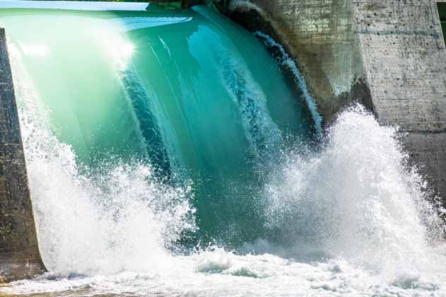 Flusswasser erzeugt durch eine Mauer geleitet einen kleinen Wasserfall