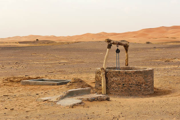 Ein alter Steinbrunnen in einer Wüste.