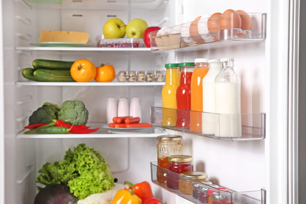 Ein offener Kühlschrank mit frischen Lebensmitteln, in dem während eines Stromausfalls kein Licht brennt.