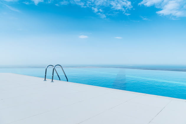 Infinity-Pool mit strahlend blauem Wasser unter blauem Himmel mit Blick aufs Meer