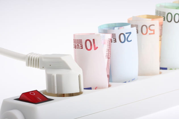 Mehrfachsteckdose mit An/Aus-Schalter und Geldscheinen aufgerollt in den Steckdosen