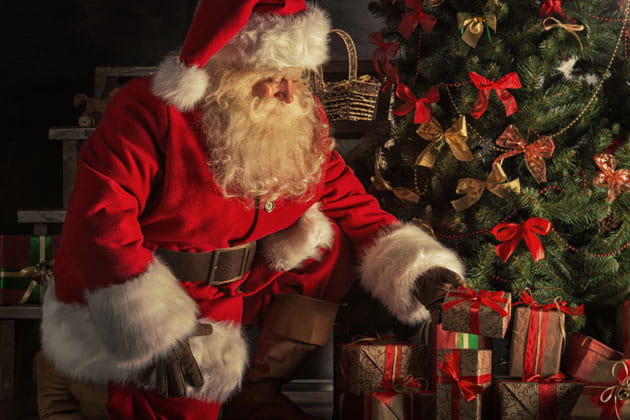Der Weihnachtsmann legt Geschenke unter den geschmückten Weihnachtsbaum