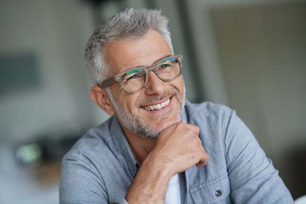 Ein Mann lacht und trägt eine Blaulichtfilter-Brille