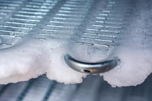 Das silberne Kühlgerippe im Gefrierschrank ist von einer Eisschicht bedeckt.