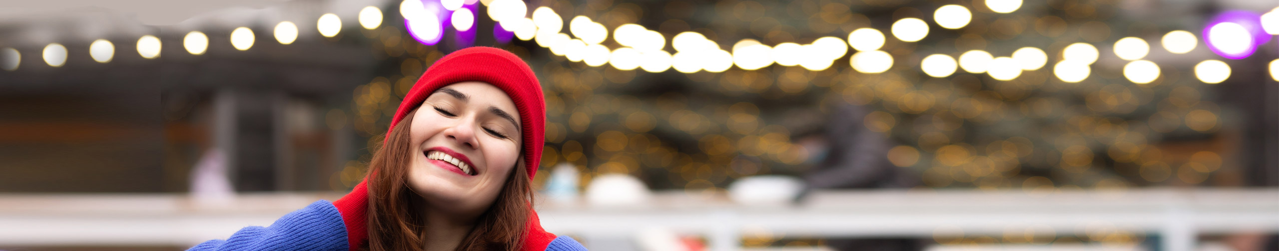 Junge Frau mit roter Mütze im Schnee