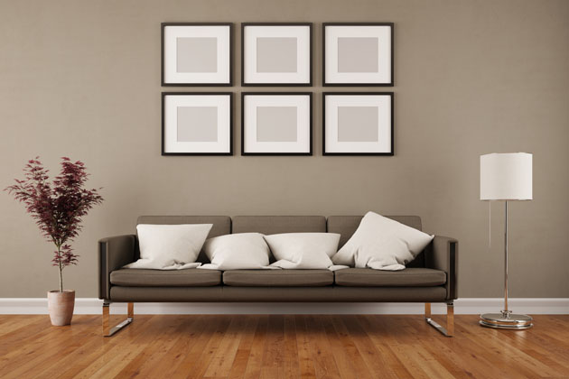 Minimalistischer Einrichtungsstil mit einem grauen Sofa und weißen Kissen im Fokus sowie schlichter Dekoration im Wohnzimmer 